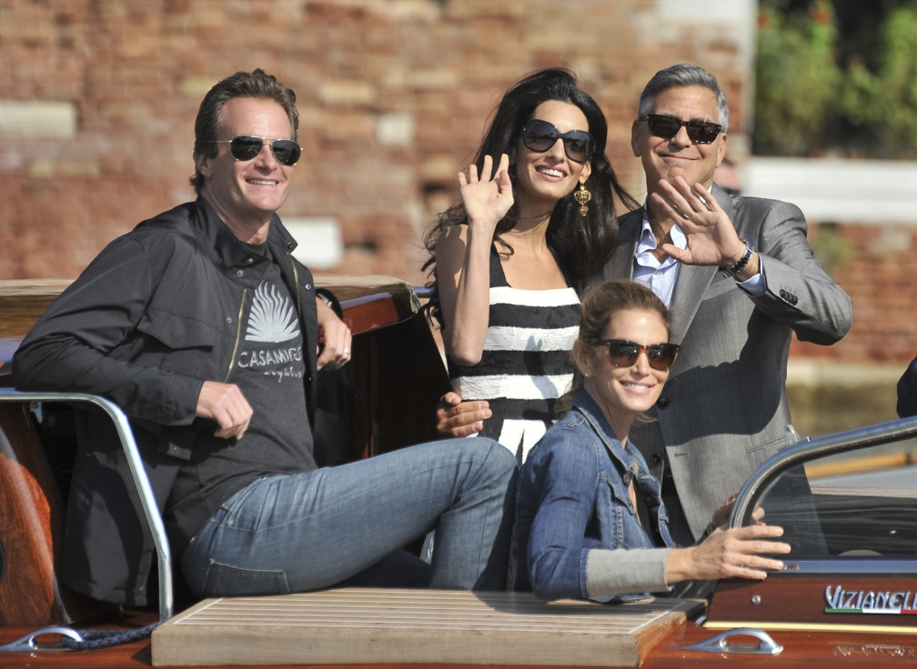 George Clooney, right, is flanked by his fiancee Amal Alamuddin, Cindy Crawford, bottom right, and her husband Rande Gerber, left, upon their arrival in Venice, Italy, Friday, Sept. 26, 2014. Clooney, 53, and Alamuddin, 36, are expected to get married this weekend in Venice, one of the world's most romantic settings. (AP Photo/Luigi Costantini)